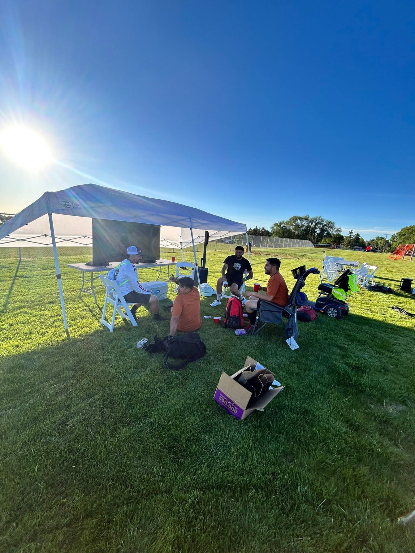 Friends relaxing under a canopy in the evening light at Copa Tricolor